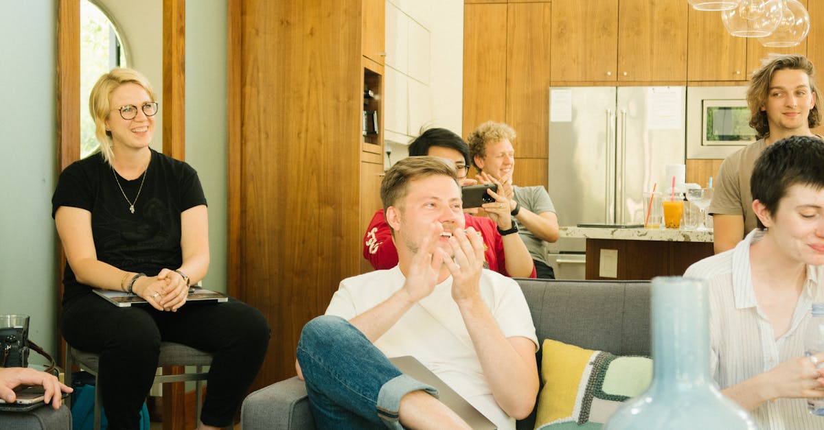 A group of diverse colleagues enjoying a casual meeting indoors with laughter and discussion.